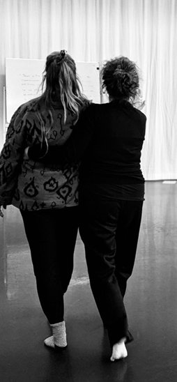 Personal guidance by a dance and theater instructor during a workshop on emotional movement.